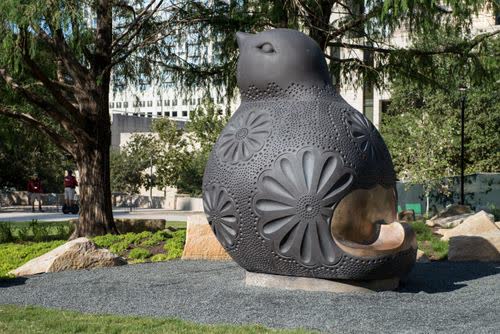 A public sculpture in a landscaped downtown space